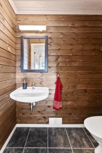 史特林Hytte Stryn skisenter的一间带白色水槽和木墙的浴室
