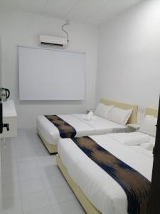 怡保SKYN SMART HOME的白色墙壁和白色地板的客房内的两张床