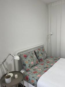 洛萨Alto Guest room的一张带枕头的床和一张带台灯的桌子