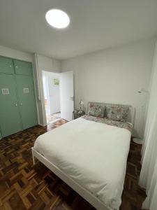 洛萨Alto Guest room的卧室配有白色的床和绿门