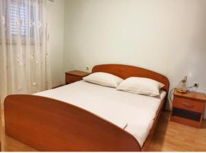 斯塔拉诺瓦利亚ApartmaniBeta的一间卧室配有一张大床和木制床头板