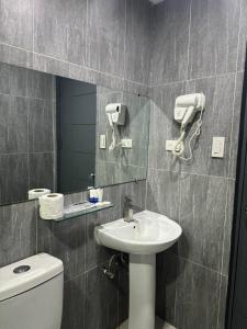 安吉利斯Deluxe Room的一间带水槽、镜子和卫生间的浴室