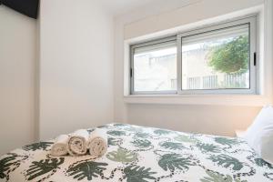 波尔图Moreira Terrace的一间卧室配有带毛巾的床和窗户。