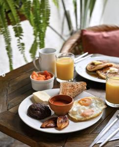 危地马拉安地瓜可可精品住宿加早餐旅馆的一张桌子,上面放着两盘早餐食品和橙汁