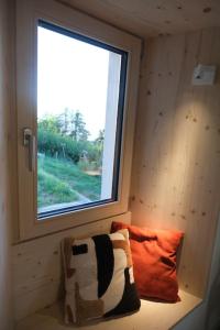 锡永Maisonnette de campagne的小房间设有窗户和枕头