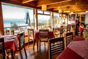 普耶韦Hotel Hosteria Entre Lagos的餐厅设有桌椅和大窗户。