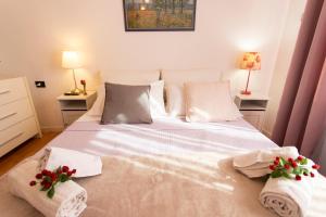 罗马Up House的一间卧室配有带毛巾和鲜花的床