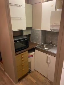 LierSpørkel Landbruk的小厨房配有白色橱柜和水槽