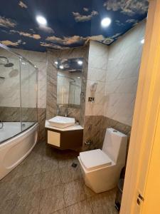 巴库Malakan Boutique Nizami Hotel的浴室配有卫生间、浴缸和水槽。