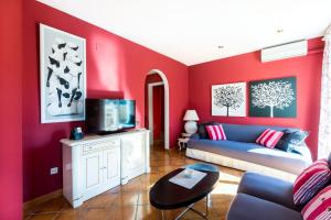 邦蒙特特雷斯诺维斯Fabuloso ROMANI entre mar y montañas的客厅设有红色的墙壁和蓝色的沙发