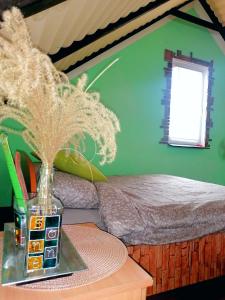 Velika RemetaSunny Side Fruska Gora -touristic estate的一间卧室配有一张床,一个花瓶摆放在桌子上