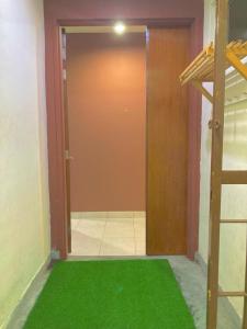 塞贝维NR CYBER ROOMSTAY 2-Shared Apartment的门前有绿色地毯的房间