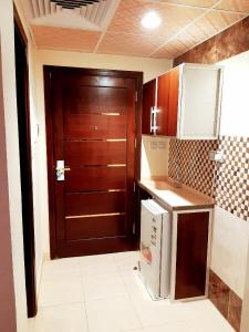 麦加فندق انوار المشاعرالفندقية的厨房设有棕色的门和冰箱。