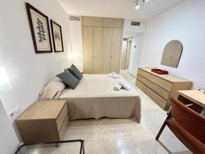 塞维利亚Estupendo apartamento junto a Plaza de España的一间卧室配有一张床、梳妆台和镜子