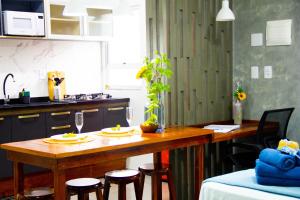 弗洛里亚诺波利斯Studio Girassol的厨房配有木桌和一些椅子