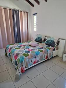 萨莱比梅Villa marigua 2的一间卧室配有一张带五颜六色棉被的床