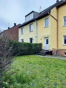 杜伊斯堡Easy to Düsseldorf Messe, 2-bedroom Apartment with kitchen and garden的前面有院子的黄色房子