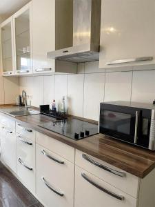 杜伊斯堡Easy to Düsseldorf Messe, 2-bedroom Apartment with kitchen and garden的厨房配有白色橱柜和黑微波炉