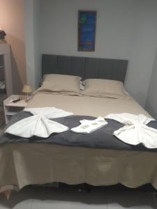 阿拉亚尔-杜卡布Pousada Canoa dos Anjos suítes的床上有两条白色毛巾