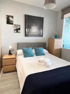 马拉加Espectacular apartamento junto al mar, con piscina en Málaga的一间卧室配有一张床,上面有两条毛巾