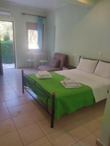 阿约斯尼奇塔斯AGIOS NIKITAS DOLPHINS的一间卧室配有一张带绿毯的床