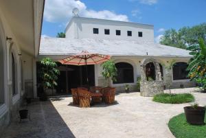 Casa Cyca, casa de campo, hasta 50 en cama c/clima的庭院配有桌椅和遮阳伞。