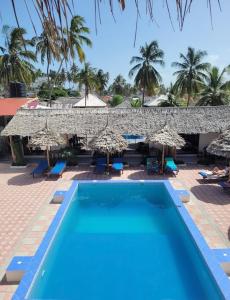 帕杰Amani Hotel Paje的一个带游泳池和遮阳伞的度假村