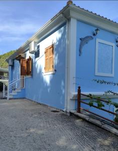 阿约斯尼奇塔斯AGIOS NIKITAS DOLPHINS的蓝色的房子,旁边是鸟