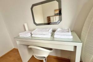 林茨Apartment 14 im Herzen von Linz的浴室设有一张带镜子和毛巾的桌子