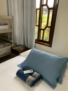 波梅罗迪Quarto Aconchego的一张带两个枕头的床和窗户