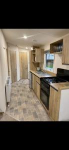 浦耳Laguna- Rockley Park Poole的厨房配有木制橱柜和炉灶烤箱。