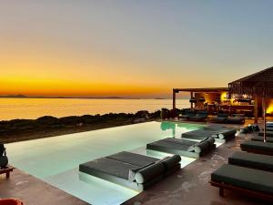 纳克索乔拉Akre Hotel的一个带躺椅的游泳池,日落时分享有海景