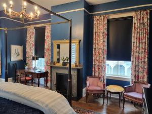 萨凡纳Thomas Weihs Haus的一间卧室设有蓝色的墙壁、一张床和一个壁炉