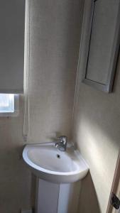 考斯51 Oaklands thorness bay Parkdean holiday resort的浴室设有白色水槽和镜子