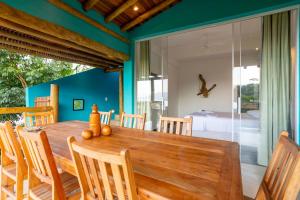 伊利亚贝拉Casa Bambolê em Ilhabela的一间带木桌和椅子的用餐室