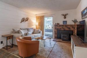 马姆莫斯湖Cozy Cabin-Style Condo in Central Location的带沙发和壁炉的客厅