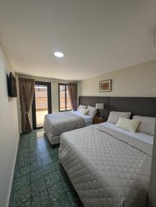 圣萨尔瓦多Hotel Abrego的酒店客房设有两张床和窗户。