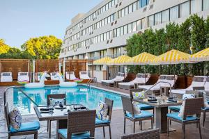 帕萨迪纳Hotel Dena, Pasadena Los Angeles, a Tribute Portfolio Hotel的酒店庭院设有桌椅和游泳池。