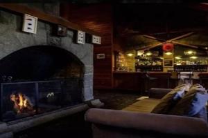 拉安戈斯图拉镇Bahia Manzano Resort的带壁炉的客厅和酒吧