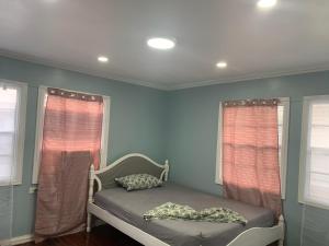 乔治敦Vacation home rental的一张位于带蓝色墙壁和窗户的房间的床铺