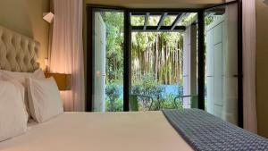 波尔图Jardim da Batalha Boutique Hotel by Shiadu的一间卧室设有一张床和一个滑动玻璃门