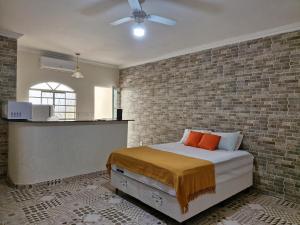 伊塔蒂亚亚Encantu's Flats的一间卧室设有一张床和砖墙