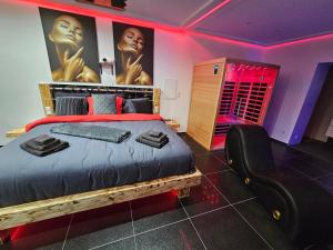 迪弗当日Magnifique Suite Spa Luxembourg的一间卧室配有一张大床和一张黑椅
