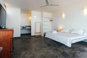 曼克拉Marmot Seashore Moonset Suite的卧室配有白色的床和电视。