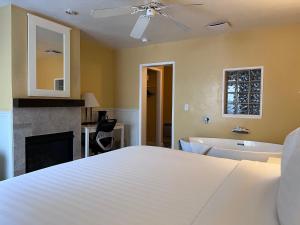 蒙特雷蒙特利湾旅馆的一间卧室配有一张床和一个浴缸,还有一个壁炉