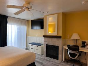 蒙特雷蒙特利湾旅馆的一间卧室配有一张床、一张桌子和一个壁炉