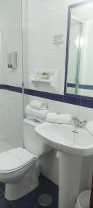 罗塔Hostal Restaurante La Giralda的白色的浴室设有卫生间和水槽。