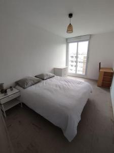 南特Appartement Courbaril à Nantes (6)的卧室设有一张白色大床和一扇窗户。