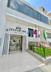 特鲁希略Jultom Inn Hotel & Suites的前面有旗帜的建筑