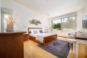 科斯镇Phillyrėa Luxury Villas的一间卧室配有一张床、一张书桌和一个窗户。